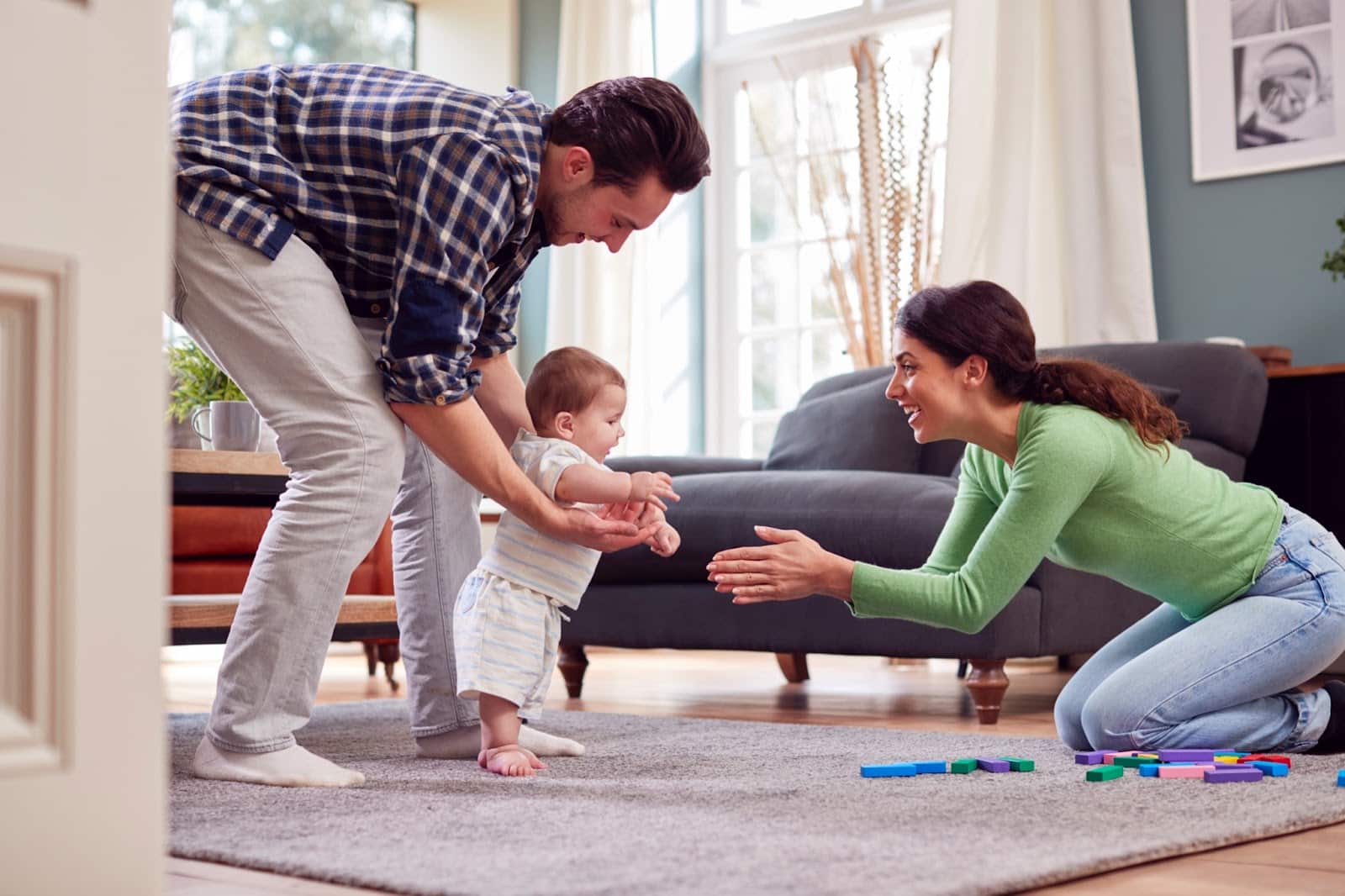 https://marshalldrygoods.com/wp-content/uploads/2024/09/transgender-family-encouraging-baby-to-take-first-2022-05-30-15-35-17-utc.jpg