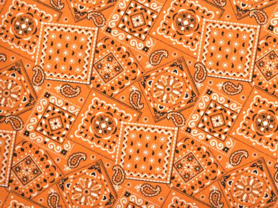Bandana-style orange cotton quilting fabric with paisley and floral block print.
