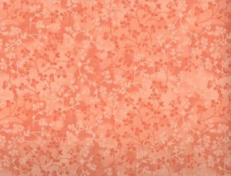 Soft peach-orange quilting fabric featuring a delicate tone-on-tone berry sprig pattern.