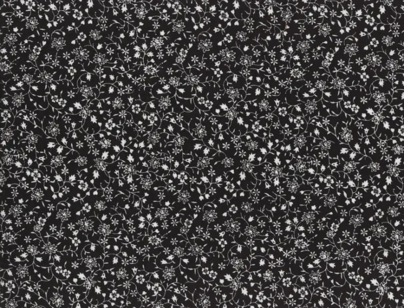 Black cotton fabric printed with an allover pattern of small white flowers and trailing vines