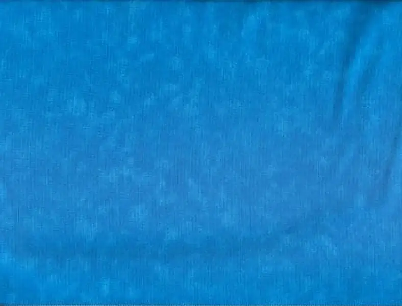 Close-up texture of solid bright blue cotton fabric with subtle mottled variation