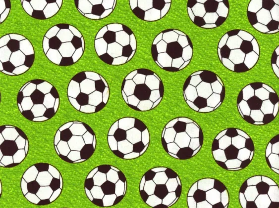 Soccer ball print fabric on green background for sports-themed sewing projects.